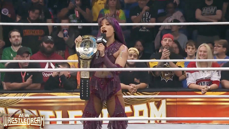 Mone in the ring with her TBS Championship belt speaking on the microphone