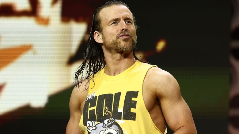 Adam Cole wearing a yellow tank top