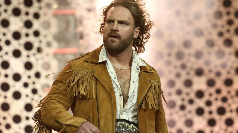 Adam Page is wearing a beige jacket