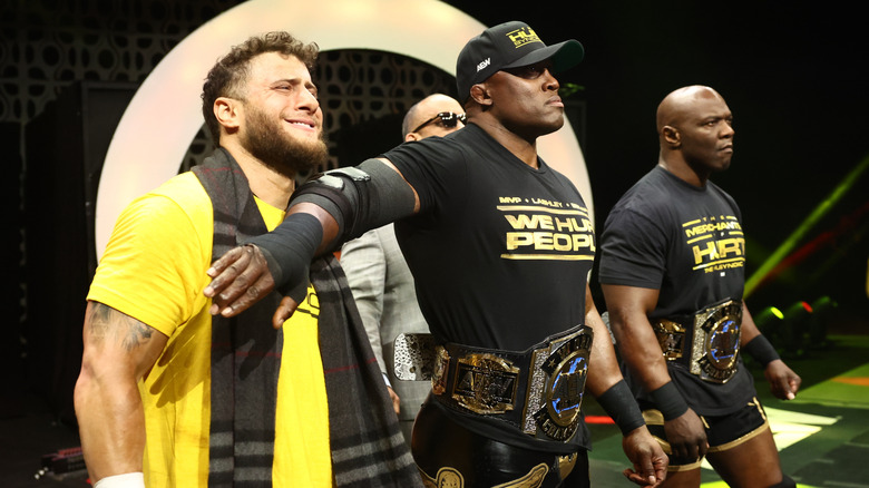 Bobby Lashley holds back MJF on the stage, and the pair are flanked by MVP and Shelton Benjamin, during an episode of 