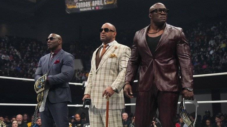 The Hurt Syndicate - Shelton Benjamin, MVP, and Bobby Lashley - in the ring with the AEW World Tag Team Championships.