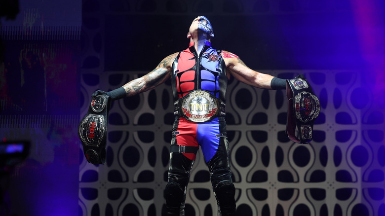 TNT Champion Dustin Rhodes holds his ROH belts on stage during his entrance on an episode of 