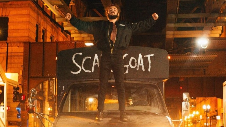 Jack Perry stands on the front hood of his Scapegoat bus