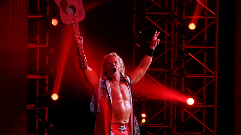 TNA and WWE Hall of Famer Jeff Jarrett holds his guitar up in the air and poses in front of the crowd before his scheduled match