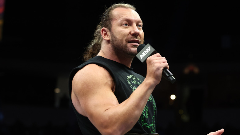 Kenny Omega cuts a promo in the middle of the ring during an episode of 