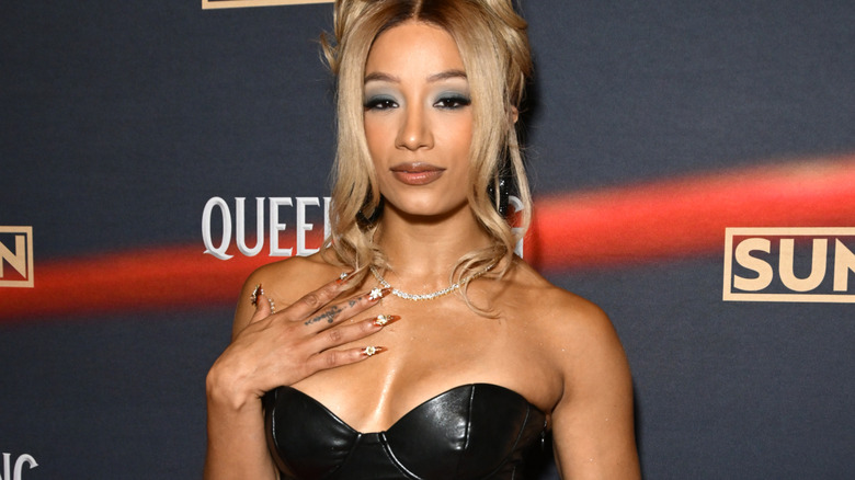Mercedes Mone wearing a silver necklace