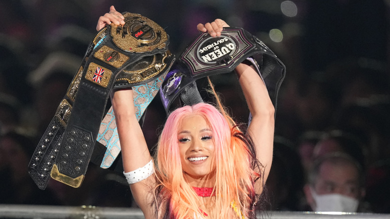 Although not all of Mercede Mone's title are captured in this picture, she is holding four of them after a title defense for NJPW.