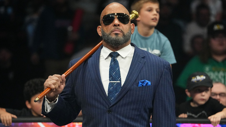 MVP wearing sunglasses with his cane on his shoulder