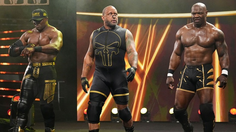 Bobby Lashley, MVP, and Shelton Benjamin standing on a stage