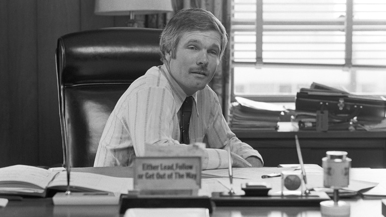 Ted Turner is sitting behind his corporate desk