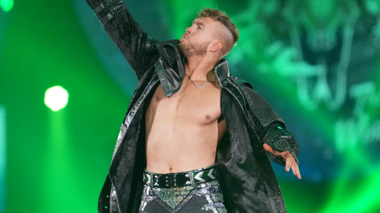 Will Ospreay is raising one arm in the air