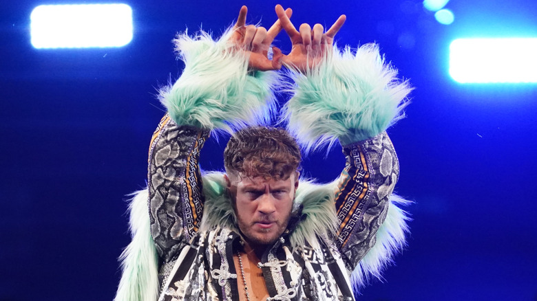 Will Ospreay puts his hands up in the air and gestures his United Empire alliance ahead of a NJPW match
