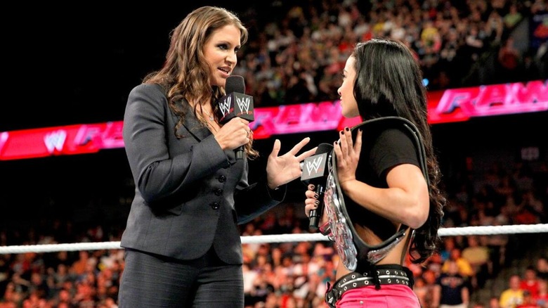Stephanie McMahon dirigiéndose a AJ Lee durante un segmento promocional en