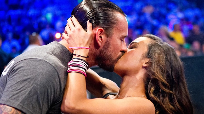 CM Punk and AJ Lee kissing on screen during a storyline.