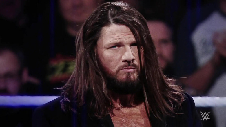 AJ Styles, in a new dark aesthetic, looks into the camera.
