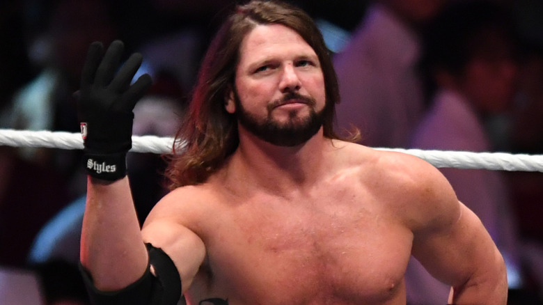AJ Styles is holding up one hand