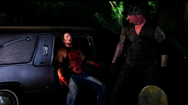 AJ Styles tries to duck into a limo but The Undertaker has caught him during their Boneyard Match at WrestleMania 36