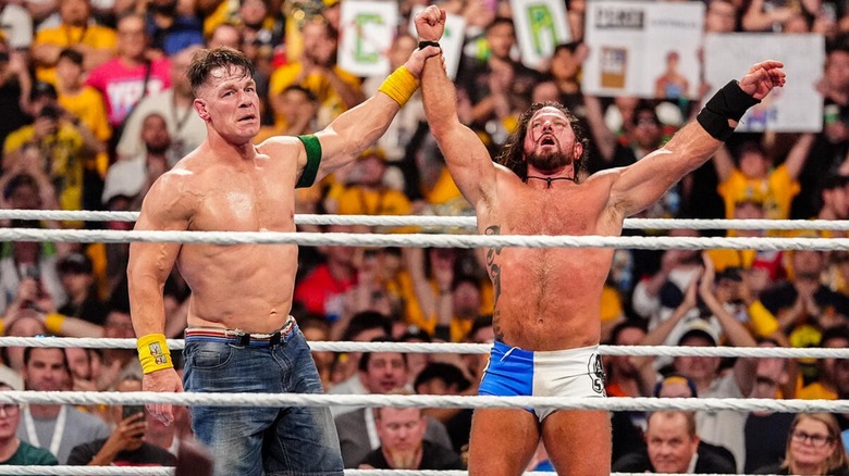 John Cena holding AJ Styles arm up after their match at Crown Jewel 2025.