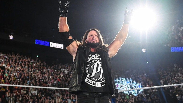 AJ Styles poses in the ring in front of fans before a segment on 