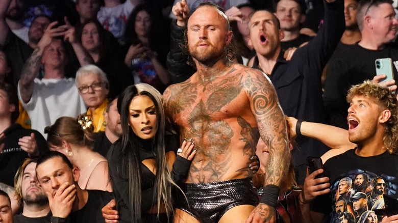 Zelina Vega holding on to Aleister Black during a match segment.