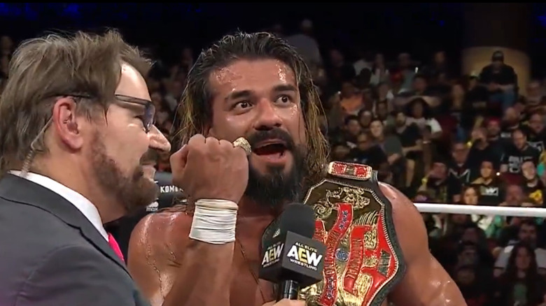 Andrade speaks to Tony Schiavone in the ring