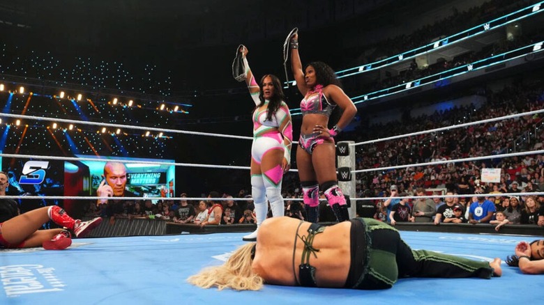 Lash Legend and Nia Jax hold the WWE Women's Tag Team Championships high after beating down the rest of the field during an episode of 