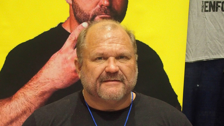 Arn Anderson, standing in front of a photo of himself pointing to his nose