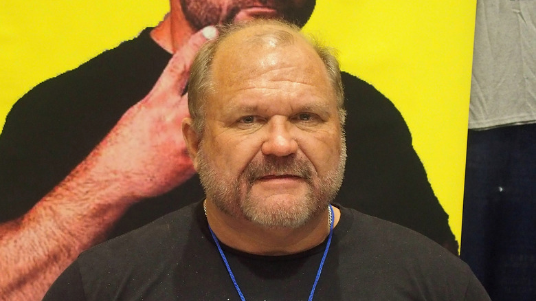 Arn Anderson poses in front of a photo of himself