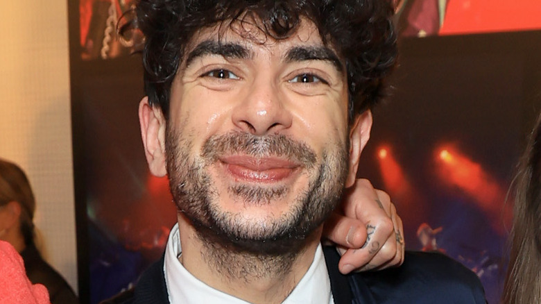 Tony Khan smiling with a hand on his shoulder