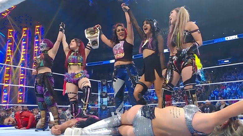 Damage CTRL, with Asuka, stands over their fallen opponents