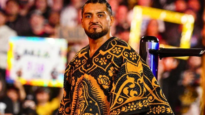 Santos Escobar is standing next to the ring post