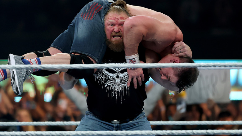 Brock Lesnar gets John Cena up on his shoulders for an F-5