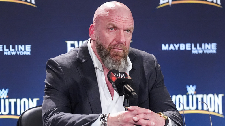Triple H sitting in front of a microphone