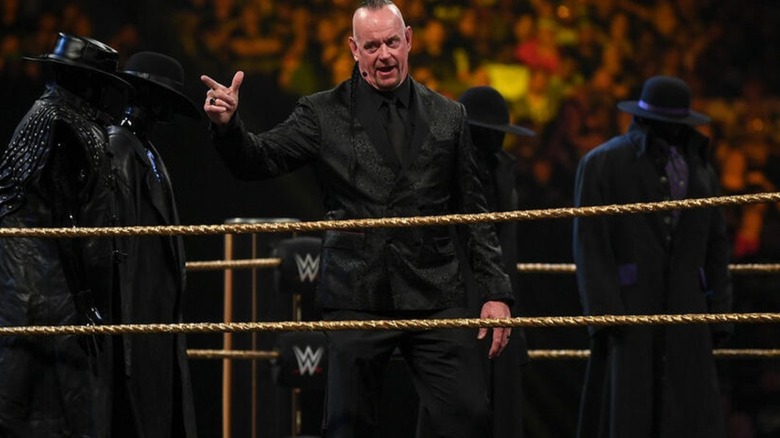 The Undertaker delivers his Hall of Fame induction speech in the ring in front of fans.