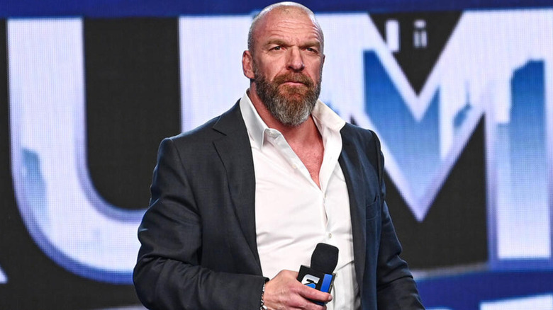 Triple H looks on as he holds a 