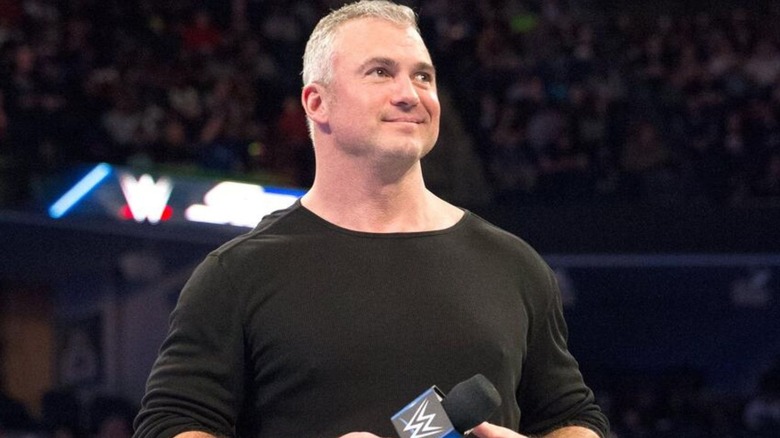 Shane McMahon stands in the ring, microphone in hand, during an appearance on 