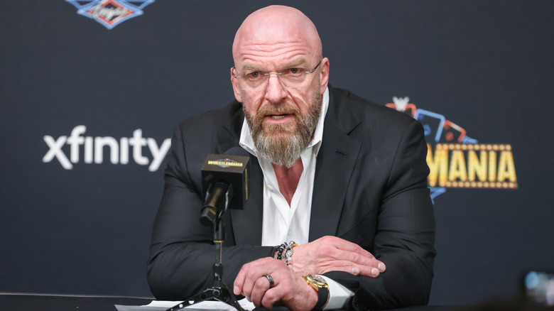 Paul Levesque at a press conference with glasses on