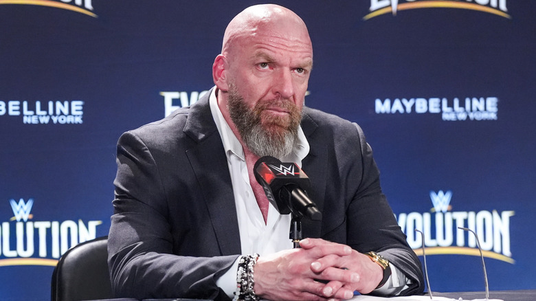 Triple H sitting in front of a microphone