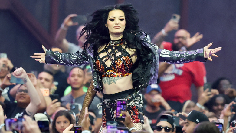Paige skips down the entrance ramp after Nikki Bella announces her replacement in the WWE Women's Tag Team Championship match at WrestleMania 42