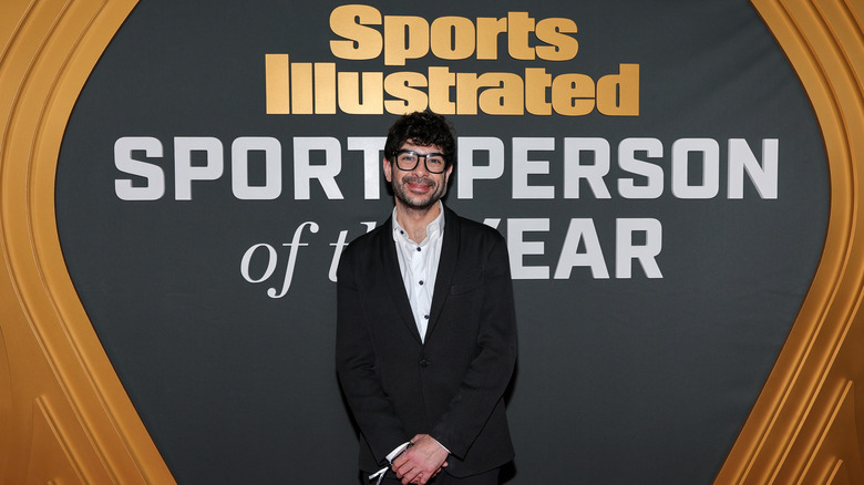 Tony Khan in front of a banner that reads Sports Illustrated Sportsperson of the Year