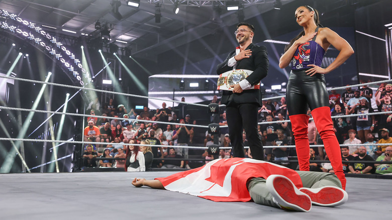 Ethan Page and Chelsea Green pose over Tavion Heights's body