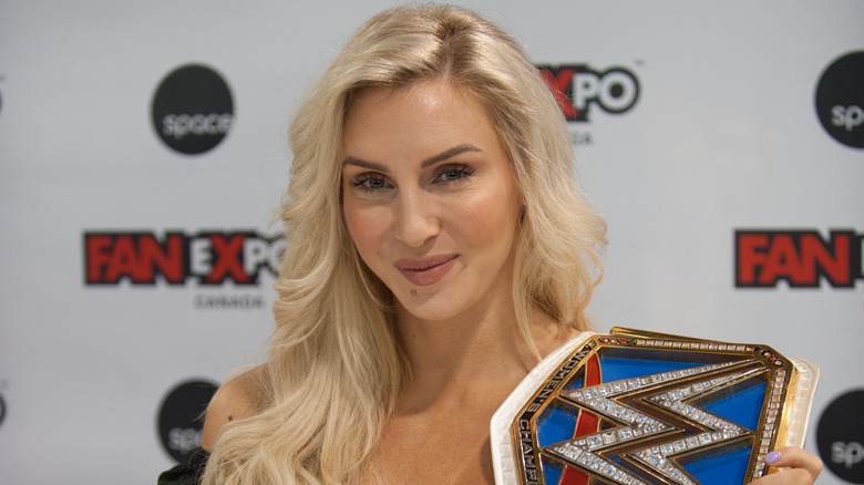 Charlotte Flair posing for photo with the WWE SmackDown Women's Championship