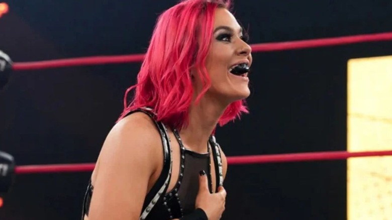 Killer Kelly sits looking shocked, yet happy, in the ring, during an episode of 