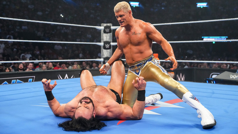 Cody Rhodes poses over Drew McIntyre