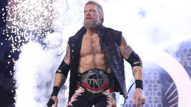 Adam Copeland stands on the stage, wearing the TNT Championship, ahead of a match on AEW programming.