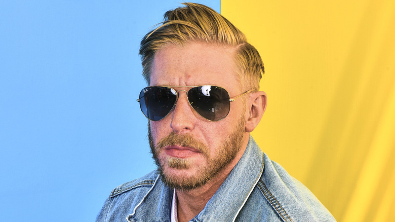 Orange Cassidy in front of a blue and yellow backdrop