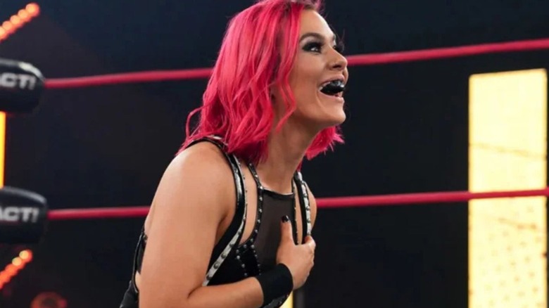 Killer Kelly sits looking shocked, yet happy, in the ring, during an episode of 