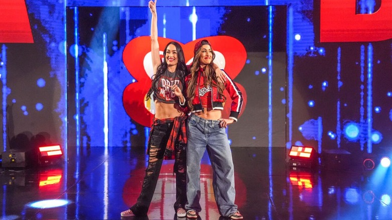 Brie and Nikki Bella pose on the stage before heading down to the ring for a promo segment on an episode of 