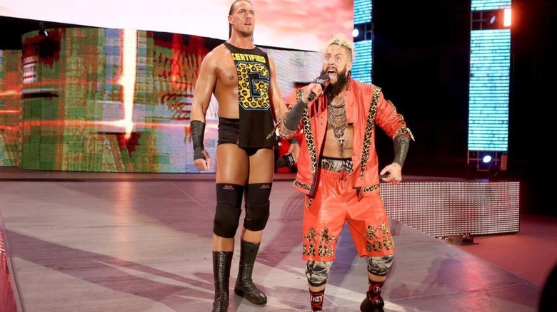Enzo Amore cuts a promo down the ramp, flanked by Big Cass, ahead of a match on 