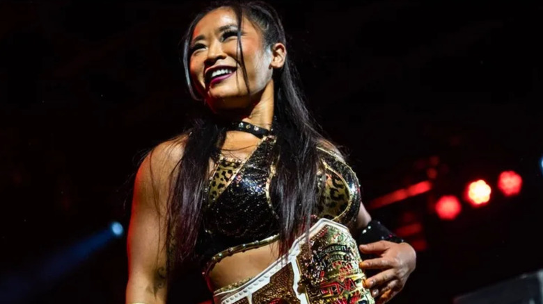 Lei Ying Lee stands on the ropes and poses with the TNA Knockouts World Championship wrapped around her wais